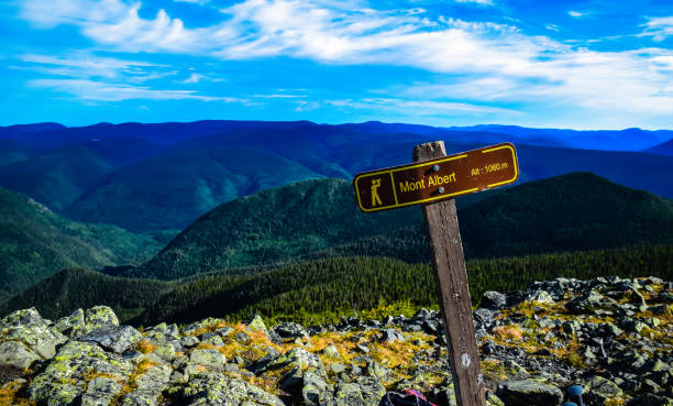 Superb rocky summit of Morios mountain and its small wooden bridge in the Charlevoix region on a warm summer day, Quebec, Canada