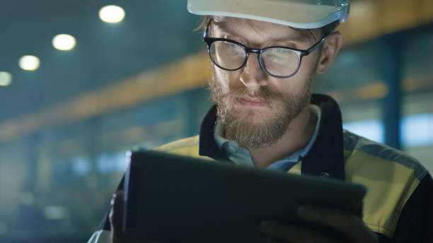 istock Engineer in hardhat is using a tablet computer in a heavy industry factory. 838527566