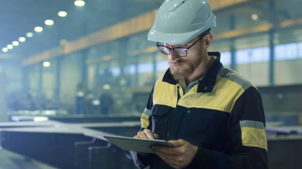 istock Engineer in hardhat is using a tablet computer in a heavy industry factory. 838527568
