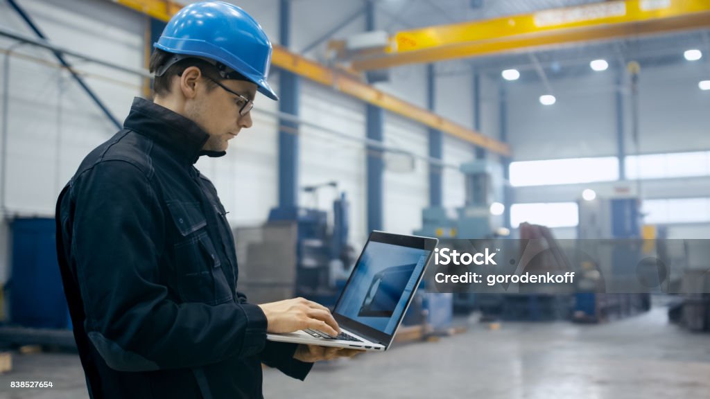 Factory Worker Using Pc Factory Worker In A Hard Hat Is Using A Laptop Computer With An ...