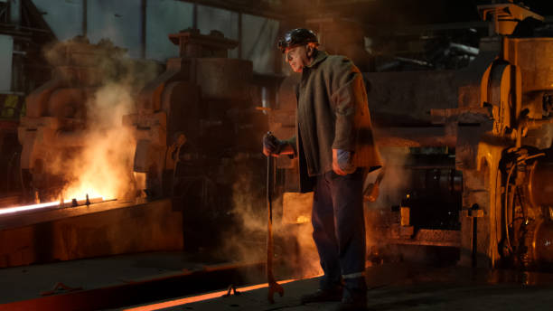 lavoratore dell'industria pesante che fa il controllo di qualità in fonderia. ambiente industriale accidentato. colpo largo. - rivoluzione industriale foto e immagini stock