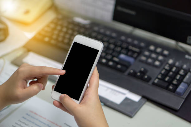 istock asian business women using smart phone in the office with keyboard and computer background 838529224