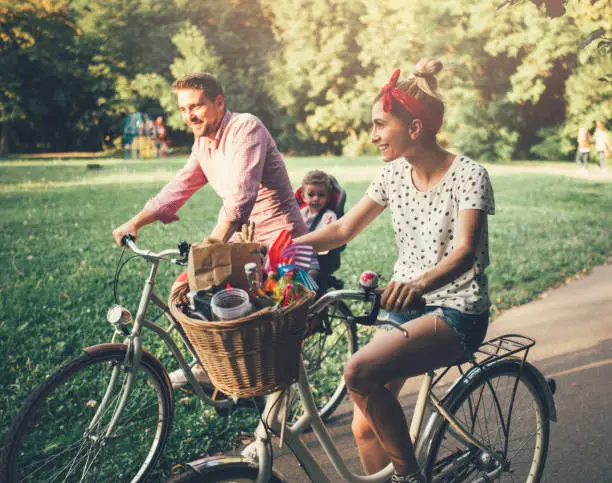 Photo of Young family riding bicycles in the park
