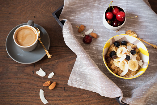Almond Milk Quinoa With Fresh Fruits, Cherries And Coffee in a Tray. Healthy Breakfast, Lifestyle Concept. Top View. Dark Wooden Background. Fitness Mood Diet. Summer Light Snack