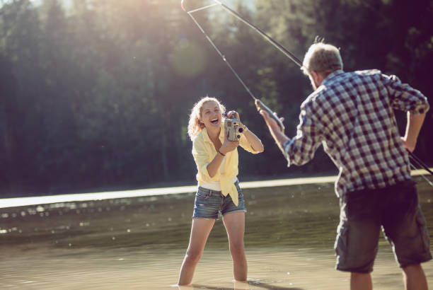 istock Woman Filming a Friend Catching Fish 838533964