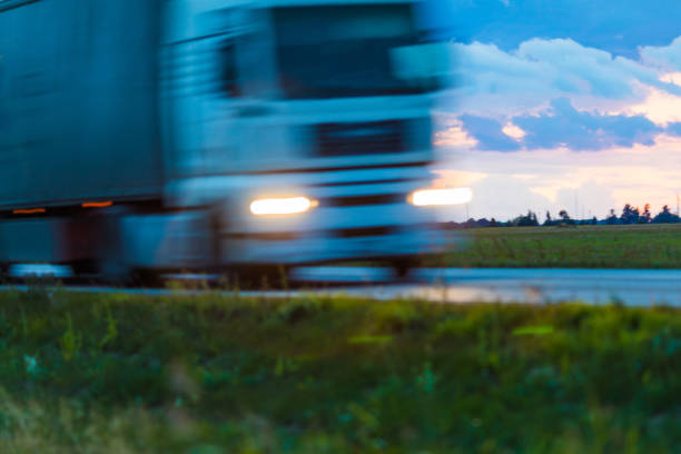 istock Speeding motion blur oncoming trucks with glowing lights on the highway after sunset. Abstract blur image background with copy space. 838534620