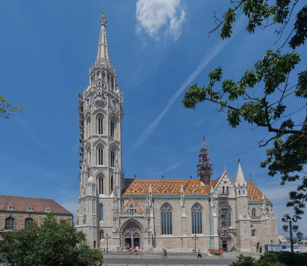 Matthias Church with its ornate tower and the intrincated colorful tile decoration of the ceiling, Budapest, Hungary.