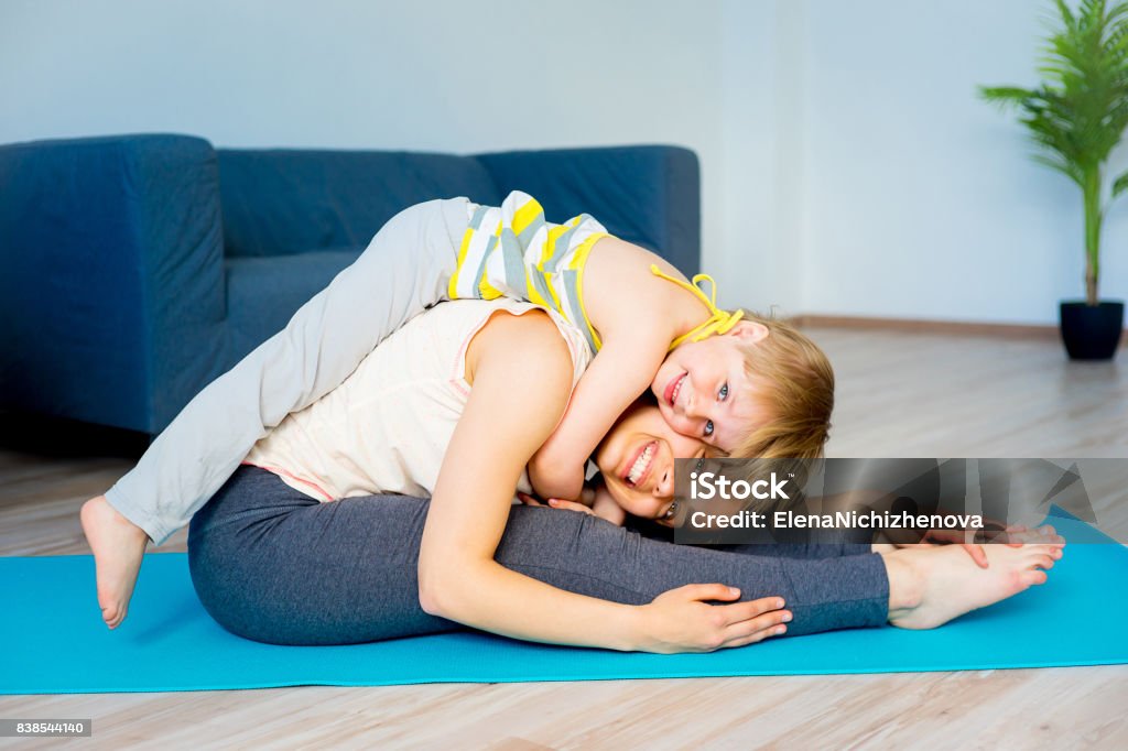 Mother is doing stretches Mother is doing stretches with her daughter 20-29 Years Stock Photo