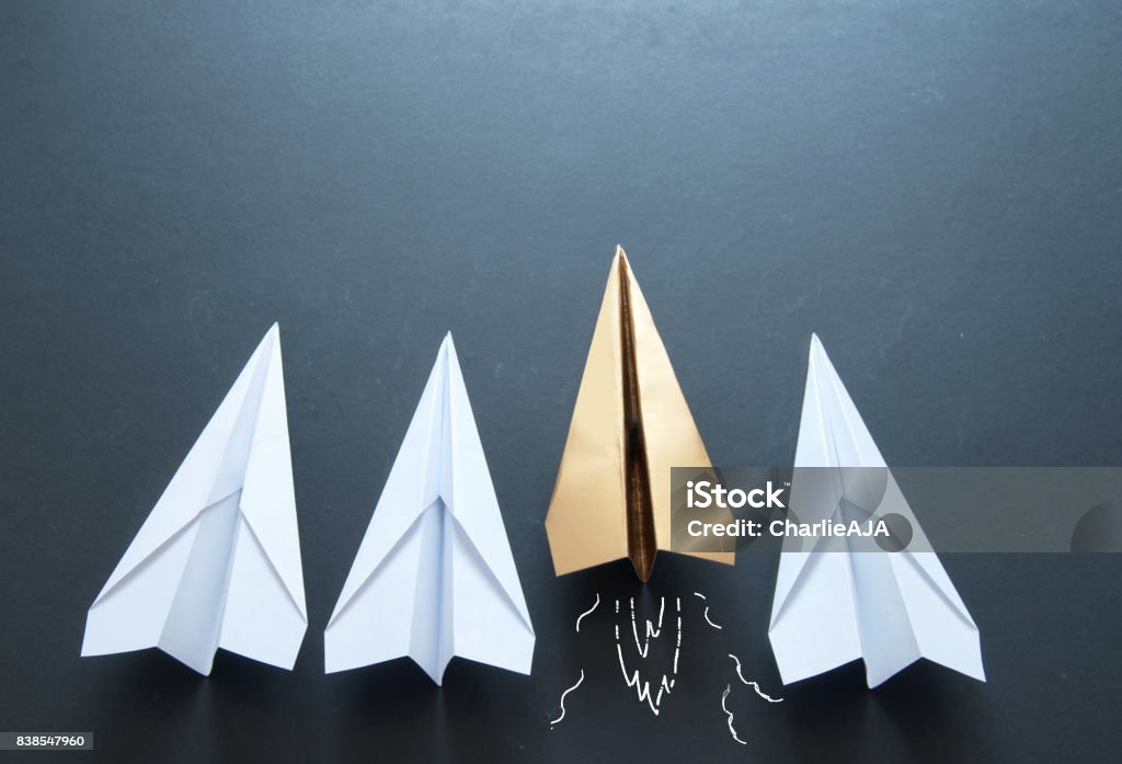 Paper plane leadership concept Gold paper plane standing out in a line Standing Out From The Crowd Stock Photo