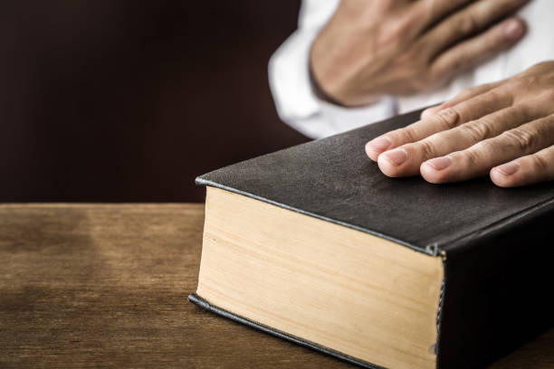 istock Man's hand swearing on the bible. Taking an oath. 838553654