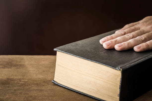 istock Man's hand swearing on the bible. Taking an oath. 838553776
