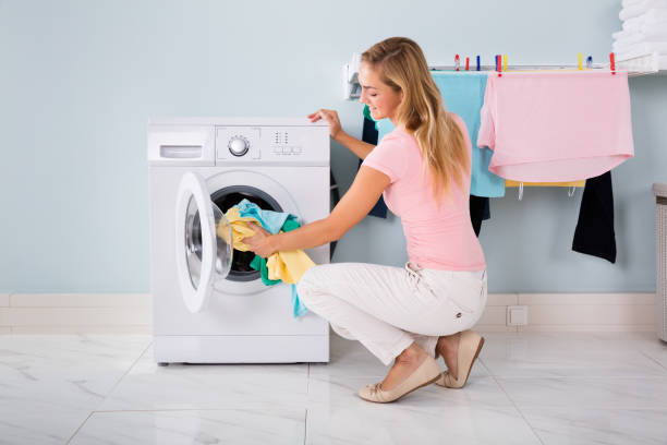 istock Woman Putting Clothes In Washing Machine 838574734