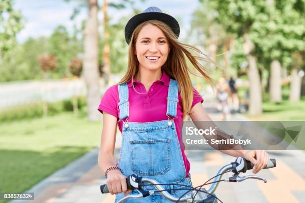 Beautiful Young Woman With Her Bicycle At The Park Stock Photo - Download Image Now - Active Lifestyle, Adult, Arts Culture and Entertainment