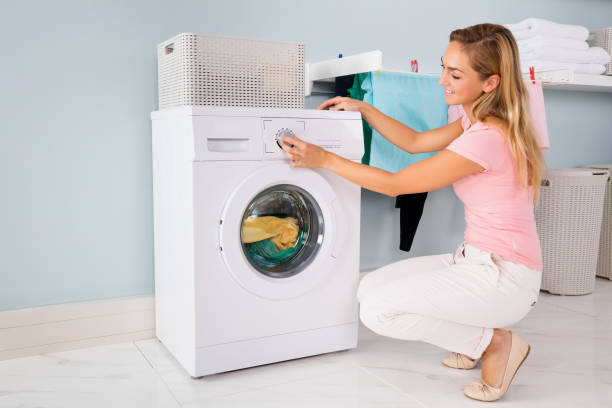 istock Woman Using Washing Machine In Utility Room 838578898