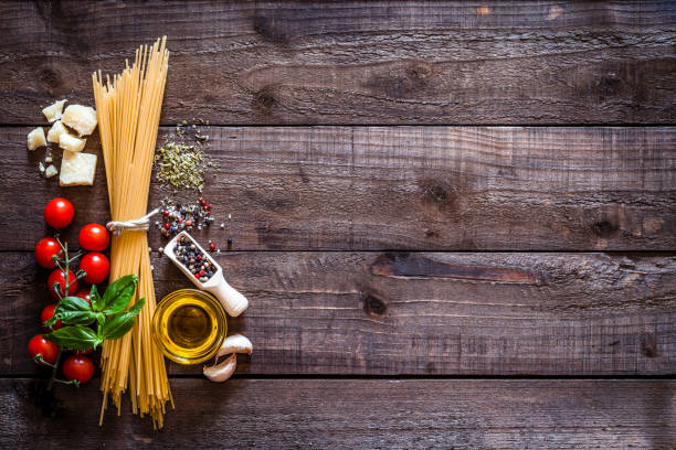 spagetti con ingredienti su tavolo rustico in legno - pasta whole wheat spaghetti raw foto e immagini stock