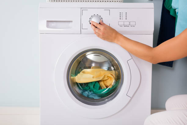 istock Person Hand Pressing Button Of Washing Machine 838579388