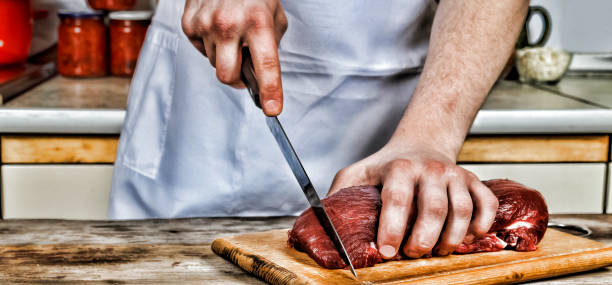 istock Butcher cutting pork meat on kitchen 838581200