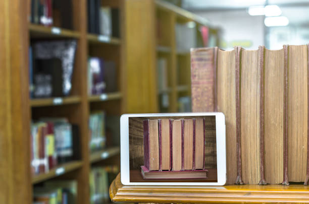 istock Tablet computer with old books on the wood table in library, Education concept 838583382