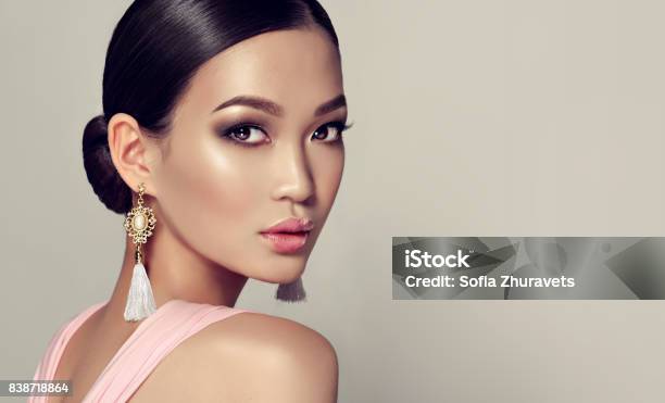 Young Gorgeous Asian Woman In A Smoky Eyes Style Make Up And Tassel Earrings Stock Photo - Download Image Now