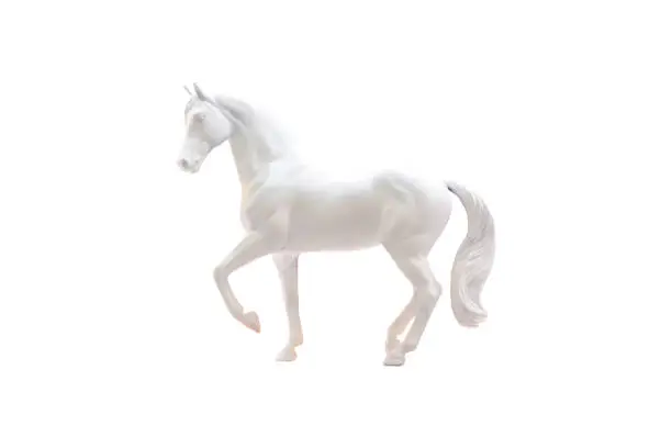 Photo of Statuette of white horse isolated on white.