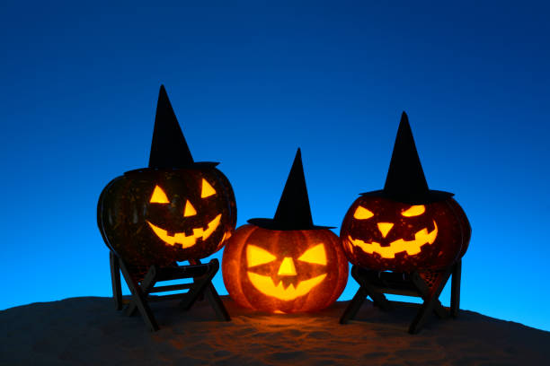 istock Carved pumpkins in composition on sand 838740830