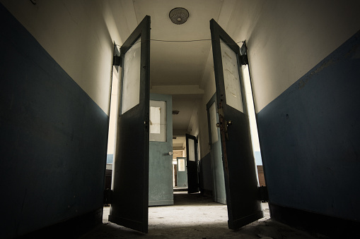 Oscuro pasillo en un sanatorio abandonado posiblemente encantado y miedo de la década de 1930 photo