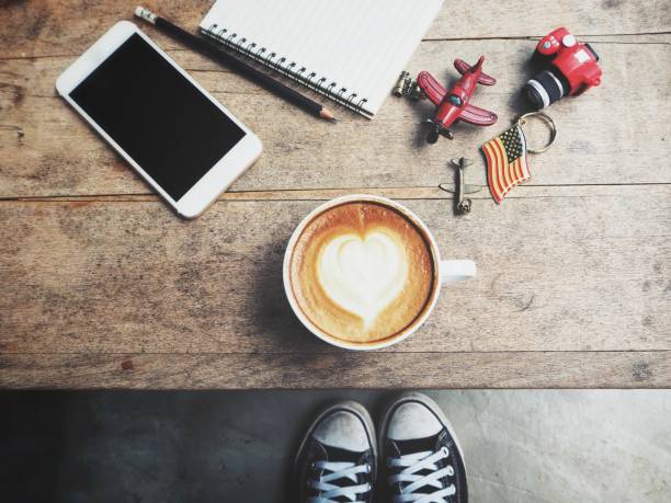 Travel accessories of smart phone with blank notepad and coffee cup with toy plane