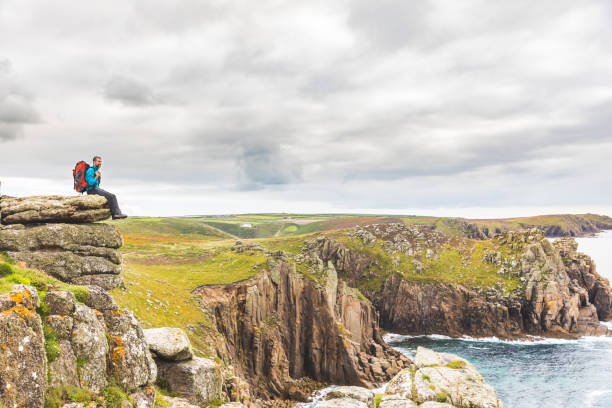istock Man sitting on a rock cliff enjoying the view 838755102