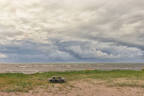 Round table for a picnic on the shore of the Baltic Sea against the background of beautiful clouds near the horizon