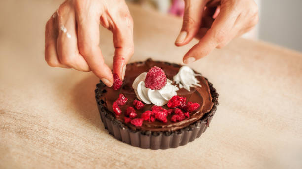 istock Woman chef preparing chocolate cake with whipped cream and raspberry 838779008