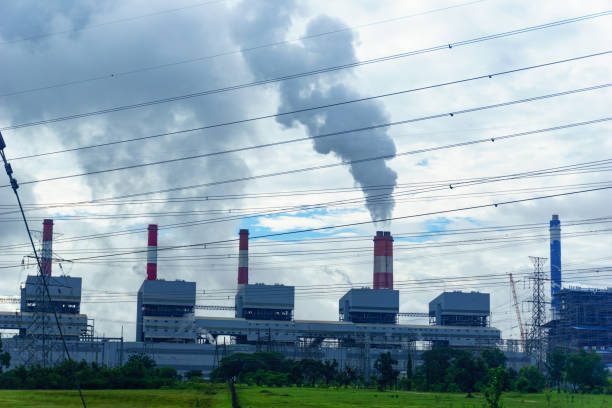 la centrale elettrica a carbone rilascia vapore dalla pila con linea di trasmissione dell'elettricità e cielo nuvoloso. - electrcity foto e immagini stock