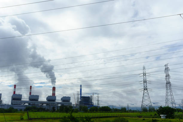 la centrale elettrica a carbone rilascia vapore dalla pila con linea di trasmissione dell'elettricità e cielo nuvoloso. - electrcity foto e immagini stock