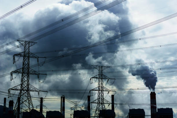 istock high voltage 500 KV transmission line and pylon with coal fire power plant release steam from stack in the morning background. electricity or climate change concept. 838795978