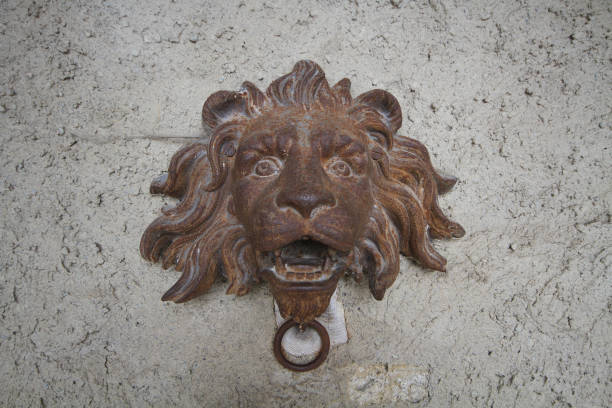istock Wall brick stone sculpture with ancient rustic steel iron crafting of lion head statue, old historical door bell in castle of Europe, wallpaper, decoration, outdoor, backgrounds 838802978