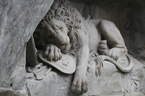 laying down Lion statue Monument at Lucerne, Switzerland, attractive sculpture landmark.  Designed by Bertel Thorvaldsen and hewn in 1820–21