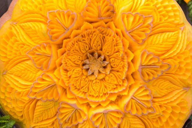 A detailed carving of a melon displays artistic skill and precision. The design features delicate patterns and floral elements, enhancing the overall presentation.