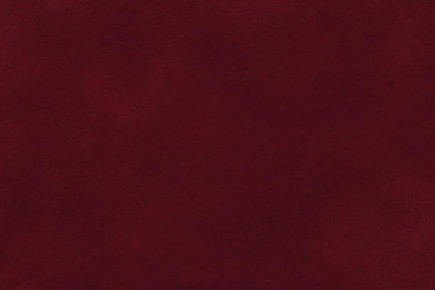 Background of dark red suede fabric closeup. Velvet matt texture of wine nubuck textile Background of dark red suede fabric closeup. Velvet matt texture of wine nubuck textile. maroon photos stock pictures, royalty-free photos & images