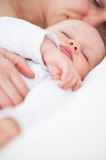 istock Cute baby sleeping next to her mother 838825048