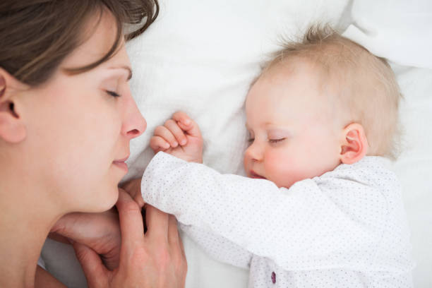 istock Peaceful woman lying on a bed with her daughter 838825464