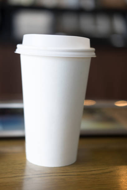 istock White tall paper cup on wood table 838827094