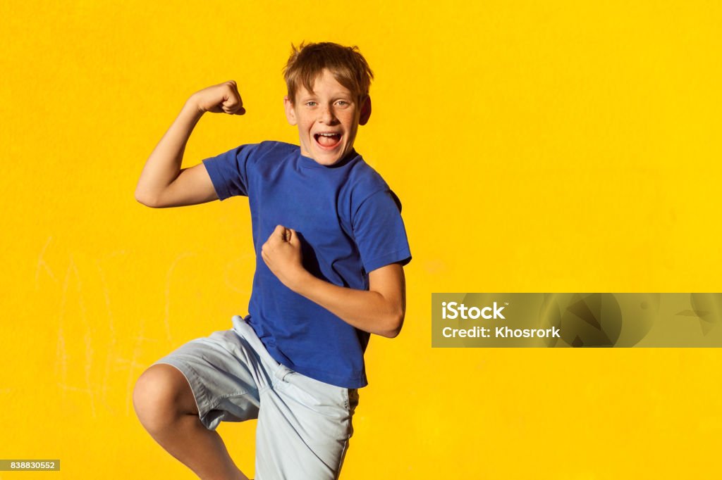 Funny an happiness freckles boy in summer Funny an happiness freckles boy in summer. Indoor, studio shot. Yellow background Teenage Boys Stock Photo