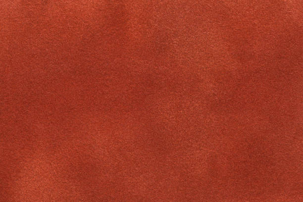 Background of dark orange suede fabric closeup. Velvet matt texture of ginger nubuck textile Background of dark orange suede fabric closeup. Velvet matt texture of ginger nubuck textile. rust colored stock pictures, royalty-free photos & images