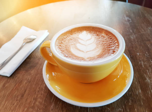 istock cup of latte coffee in yellow cup on wooden table 838856834