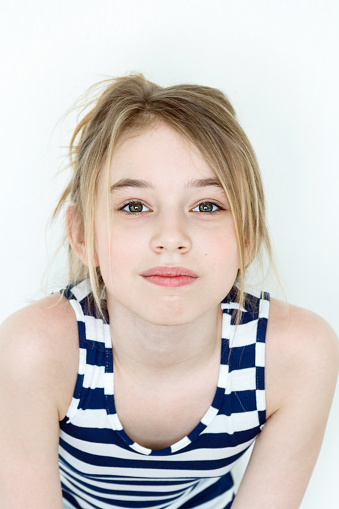 Portrait of beautiful young girl with blondie hair. Confident female wearing blue shirt while posing at grey background. Copy space.
