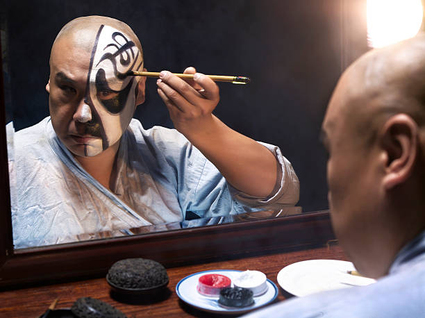 hombre aplicar maquillaje de ópera china - vestuario entre bastidores fotografías e imágenes de stock