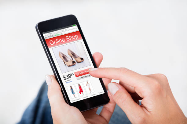 Close-up Of Woman Hand Shopping Online Purchasing Footwear Using Mobile Phone