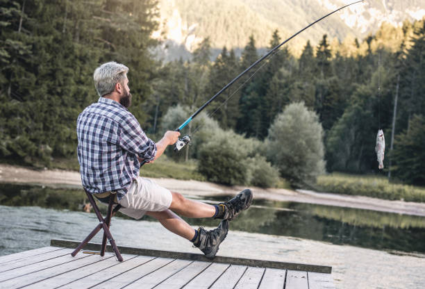 istock Young Man Fishing Beside Lake 838901754