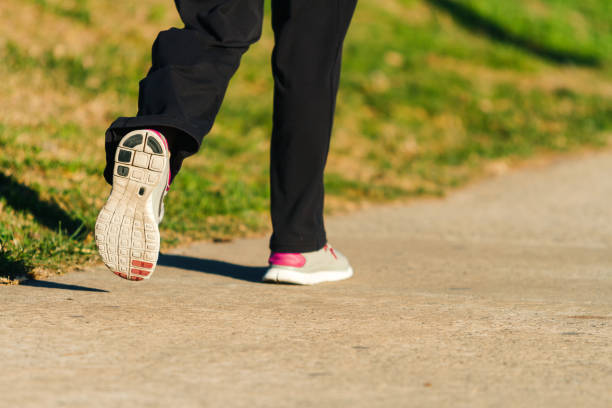 istock Woman's legs with leggings and sneakers walking along a path 838902906