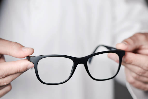istock optician man bringing a pair of eyeglasses 838906544