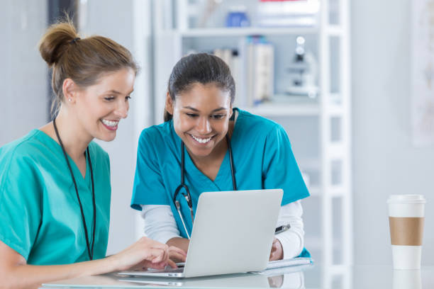 gli studenti infermieristici lavorano insieme al progetto di ricerca - laptop doctor using computer nurse foto e immagini stock
